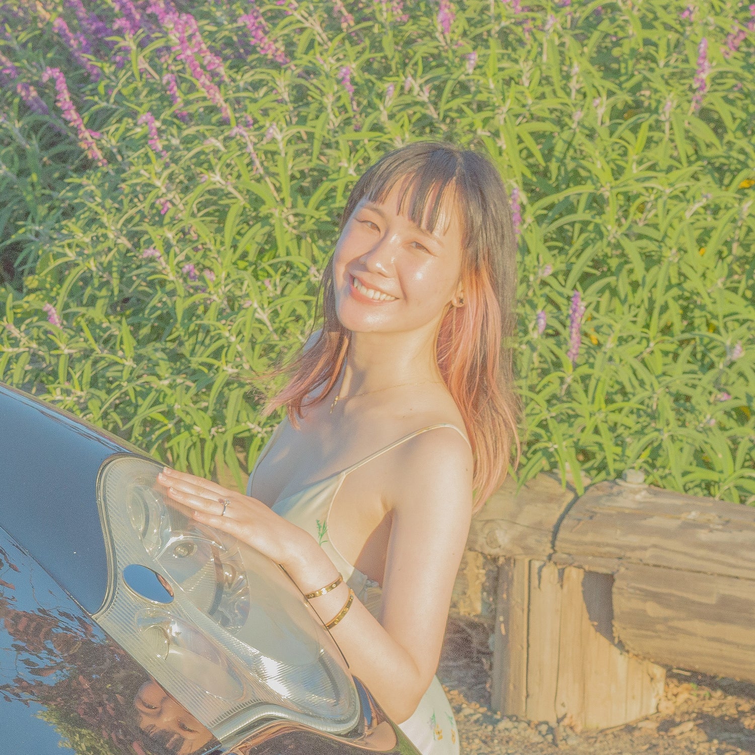 Woman sitting by a car with a floral background