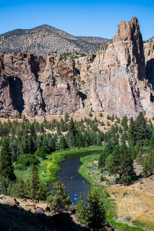 Scenic view of a river flowing through a valley with rocky cliffs and trees.