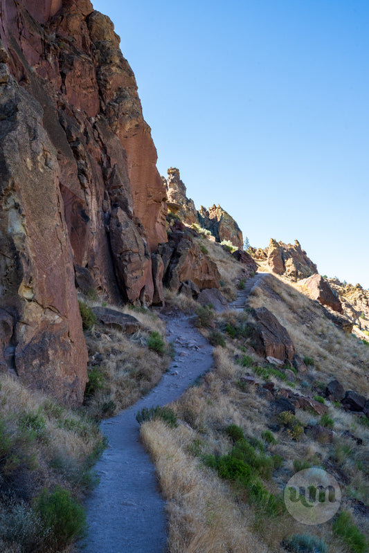 Winding trail through rocky landscape with clear blue sky