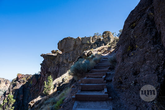 Stairway leading up a rocky cliff with clear blue sky