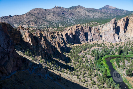 Scenic view of a mountainous landscape with a river and cliffs.