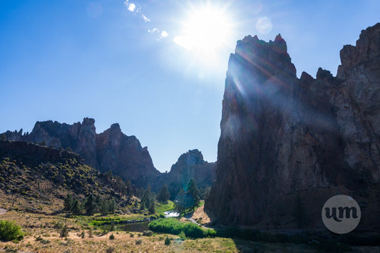 Sunlight beams through rocky cliffs in a mountainous landscape